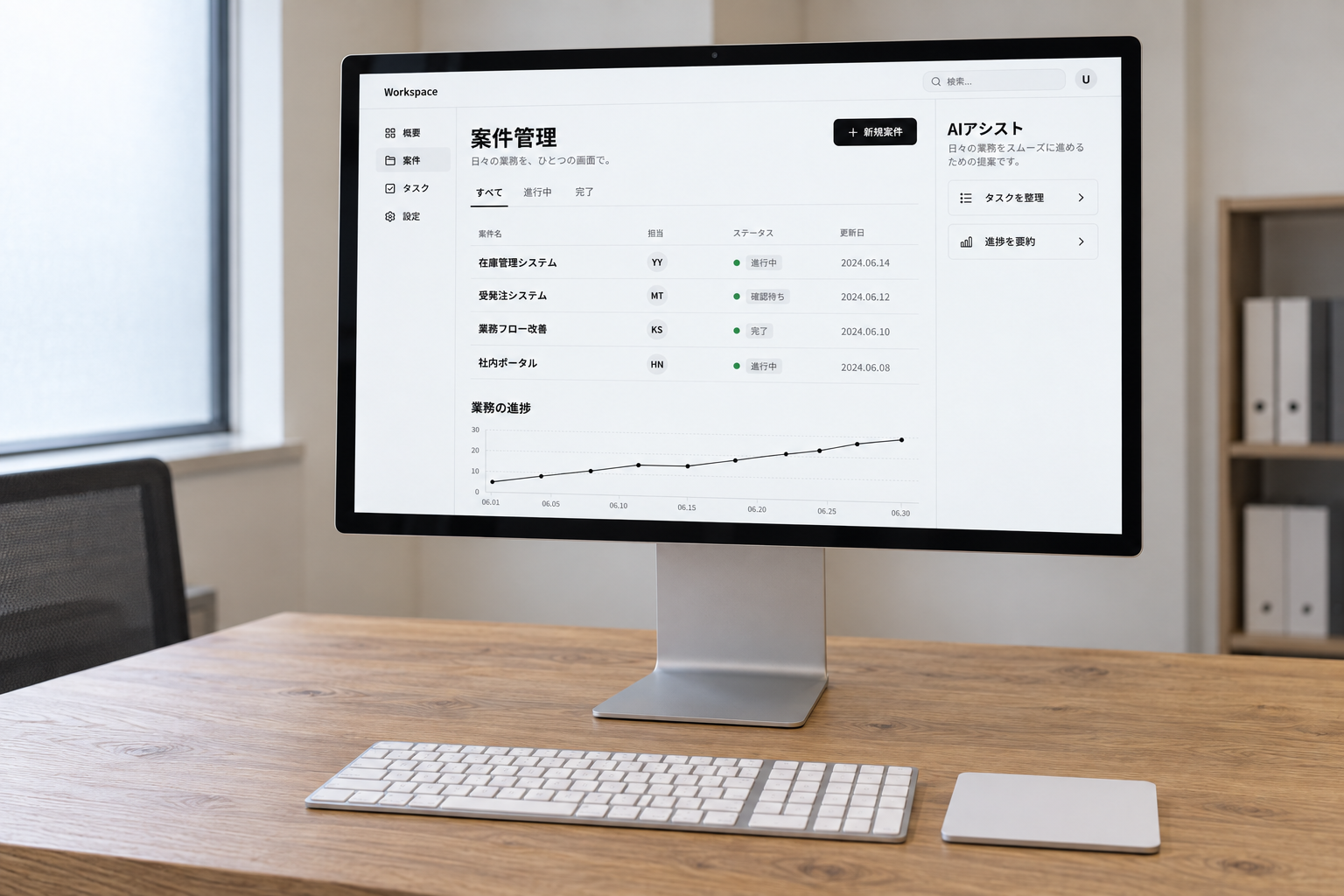 自然光の入るオフィスで、Studio Displayに業務システムの案件管理画面を映した写真風イメージ